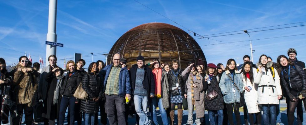 Ma Art and Science students, tutors and members from CERN standing for a photograph together with a bright blue sky backdrop.