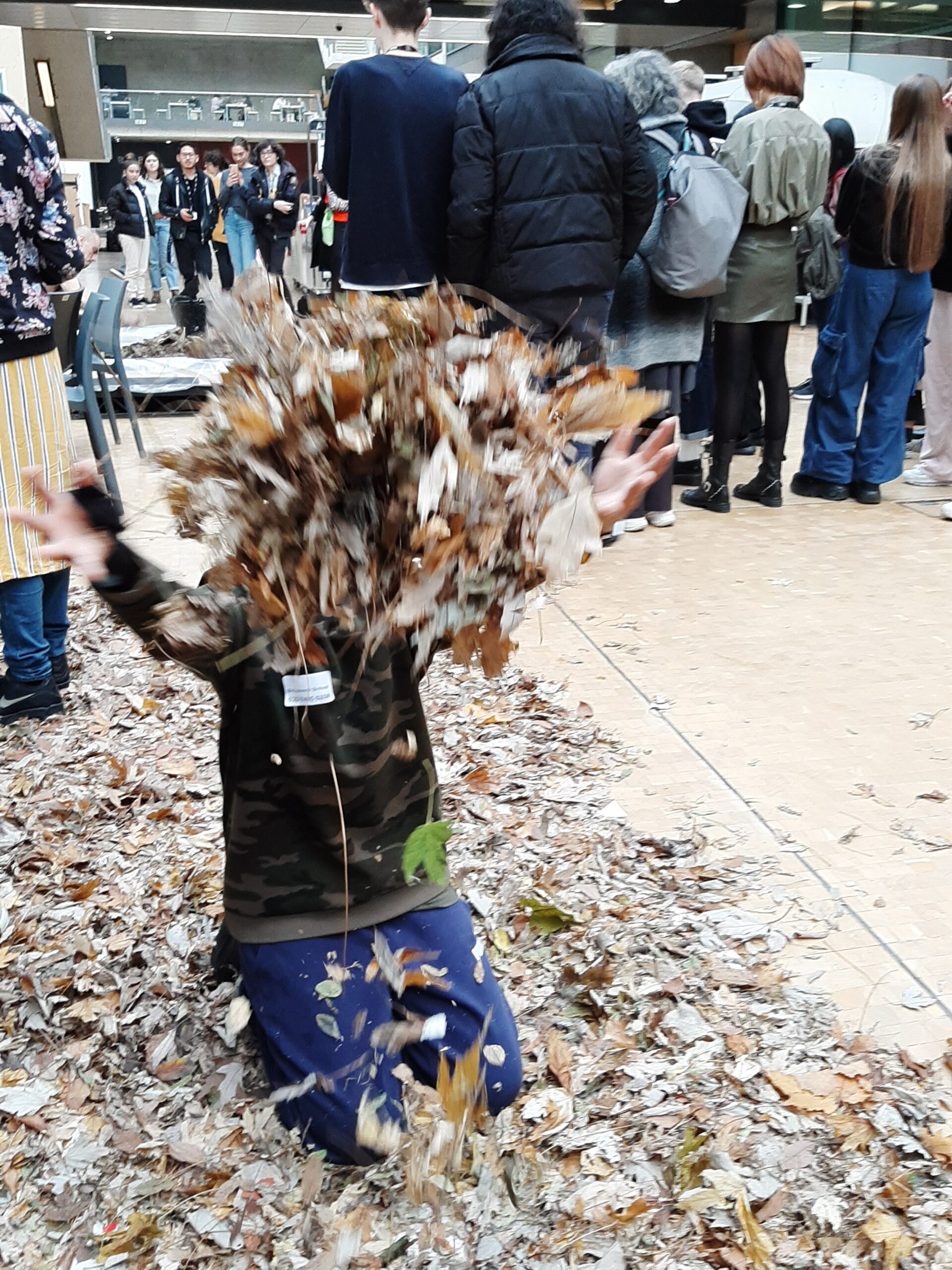 A child throwing dried leaves into the air