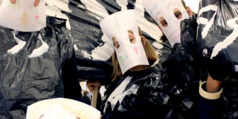 Image of several students with white masks on and posing in front of the camera