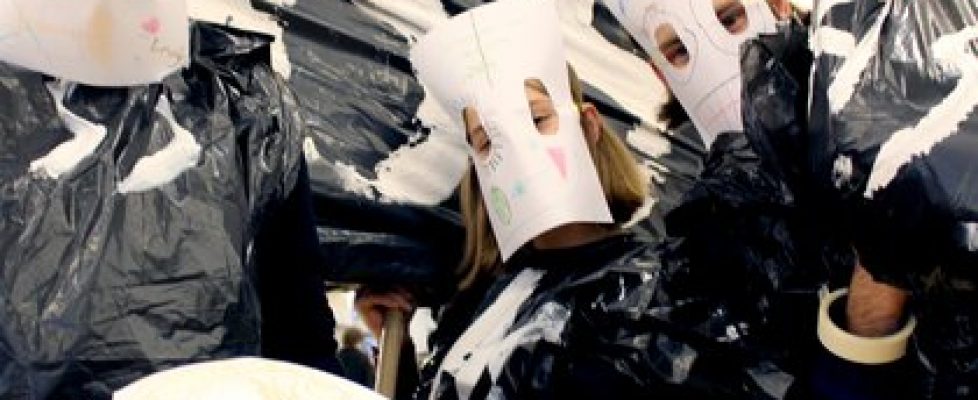 Image of several students with white masks on and posing in front of the camera